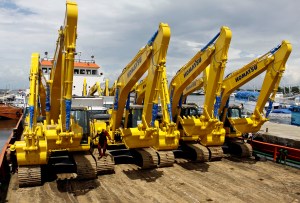 Pekerja mengatur sejumlah alat berat yang akan dikirim ke Sorong untuk kebutuhan tambang, di atas kapal pengangkutan, di Pelabuhan Paotere, Makassar, Sulsel, Sabtu (1/3). Himpunan Alat Berat Indonesia (Hinabi)  menargetkan produksi alat berat dalam negeri berkapasitas 10-30 ton digunakan untuk proyek konstruksi dan tambang pada tahun 2014 tumbuh 6% menjadi 6.500 unit dari tahun 2013 sebesar 6.127 unit. ANTARA FOTO/Ekho Ardiyanto/ss/pd/14